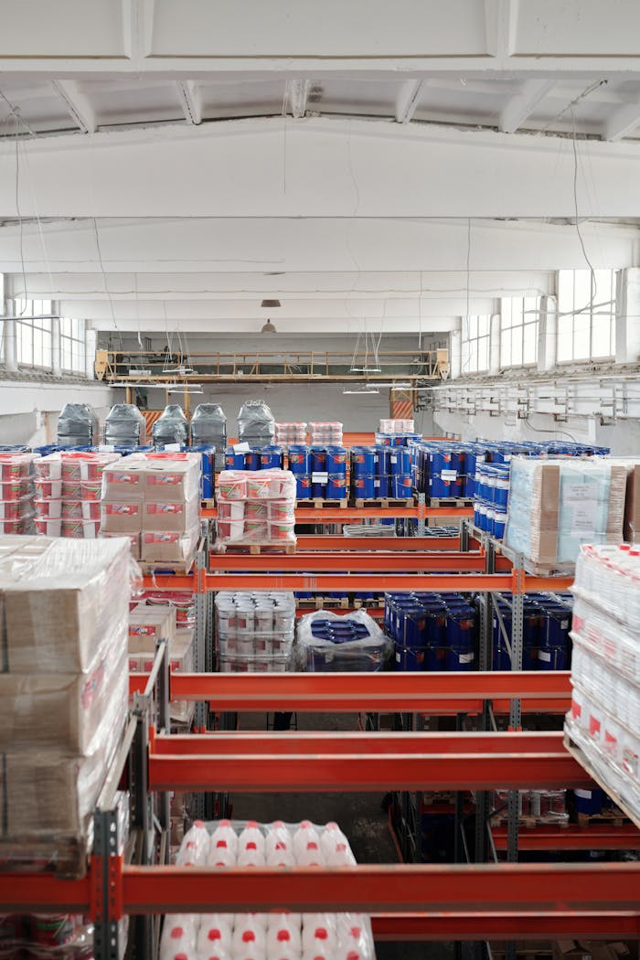 who-we-are Interior of a large warehouse with neatly organized goods on shelves, ready for shipment.