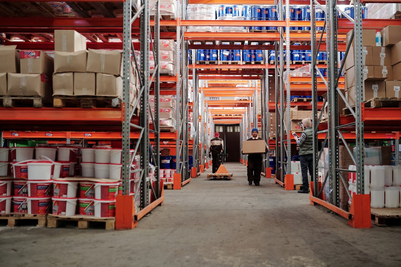 journey Warehouse interior showing workers handling boxes and organized shelves filled with products.